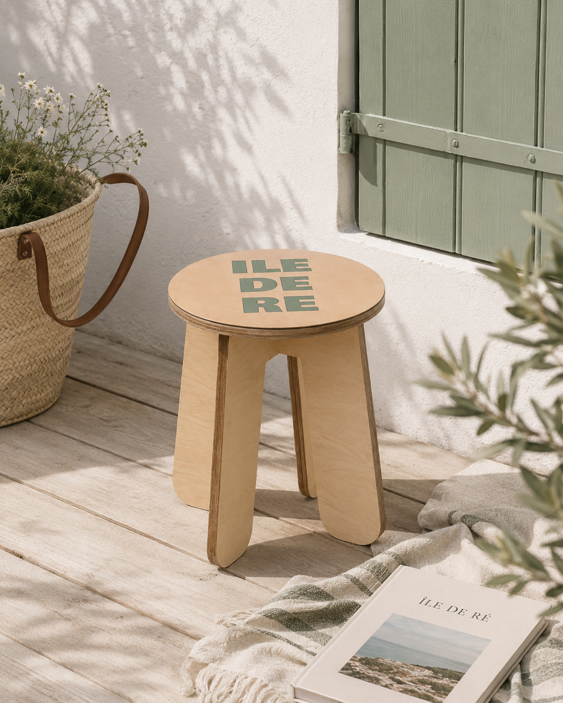 Tabouret, guéridon ou chevet avec motif "ile de ré" vert sauge sur fond beige sur une terrasse de maison rétaise. Produit fabriqué par Hey Ben !, atelier d'ébénisterie à Loix sur l'île de ré fondé par Benoît Maltier