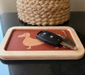 Vide-poche ou petit plateau en bois et linoléum motif teckel beige sur fond rouge. Produit fabriqué par Hey Ben !, atelier d'ébénisterie à Loix sur l'île de ré